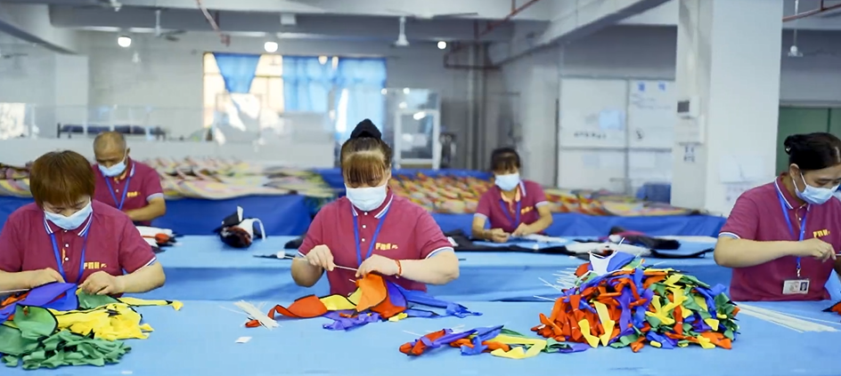 Modern textile manufacturing floor with automated machinery and workers in protective clothing